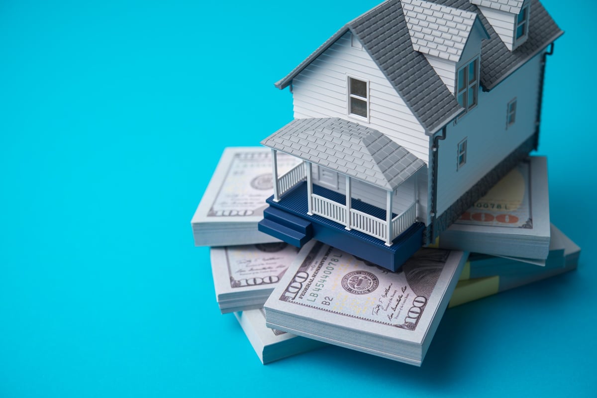 House model on heap US dollar banknotes home equity concept
